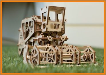 Combine ist ein 3D-Bausatzmodell aus Holz, das verschiedene Variationen (Varianten) der Mechanik bietet. Beim Fahren des Mähdreschers dreht sich die Winde (Scheibe) wie im eigentlichen Prototyp. Das Modell verfügt über eine eingebaute Geheimbox im linken Teil der Kabine. Der mechanische Mähdrescher beginnt mit einer einfachen Bewegung oder einer schnellen Drehung des großen Hinterrads. Auf der anderen Seite der Kabine befindet sich ein Hebel, der verriegelt oder abgesenkt werden kann. Der Mähdrescher arbeitet nach dem (prinzipiellen) "Gummimotor". Ein tolles Geschenk für ältere Jungen